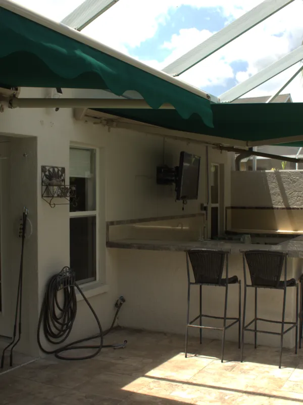 Green retractable awning extended along the rear elevation