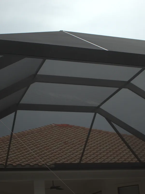 Cage roof framing from beneath, panels meeting a barrel-tile roof