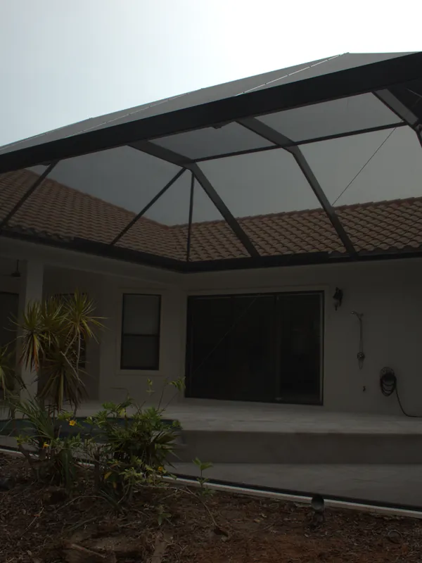 Clear-span pool cage over a screened lanai and patio