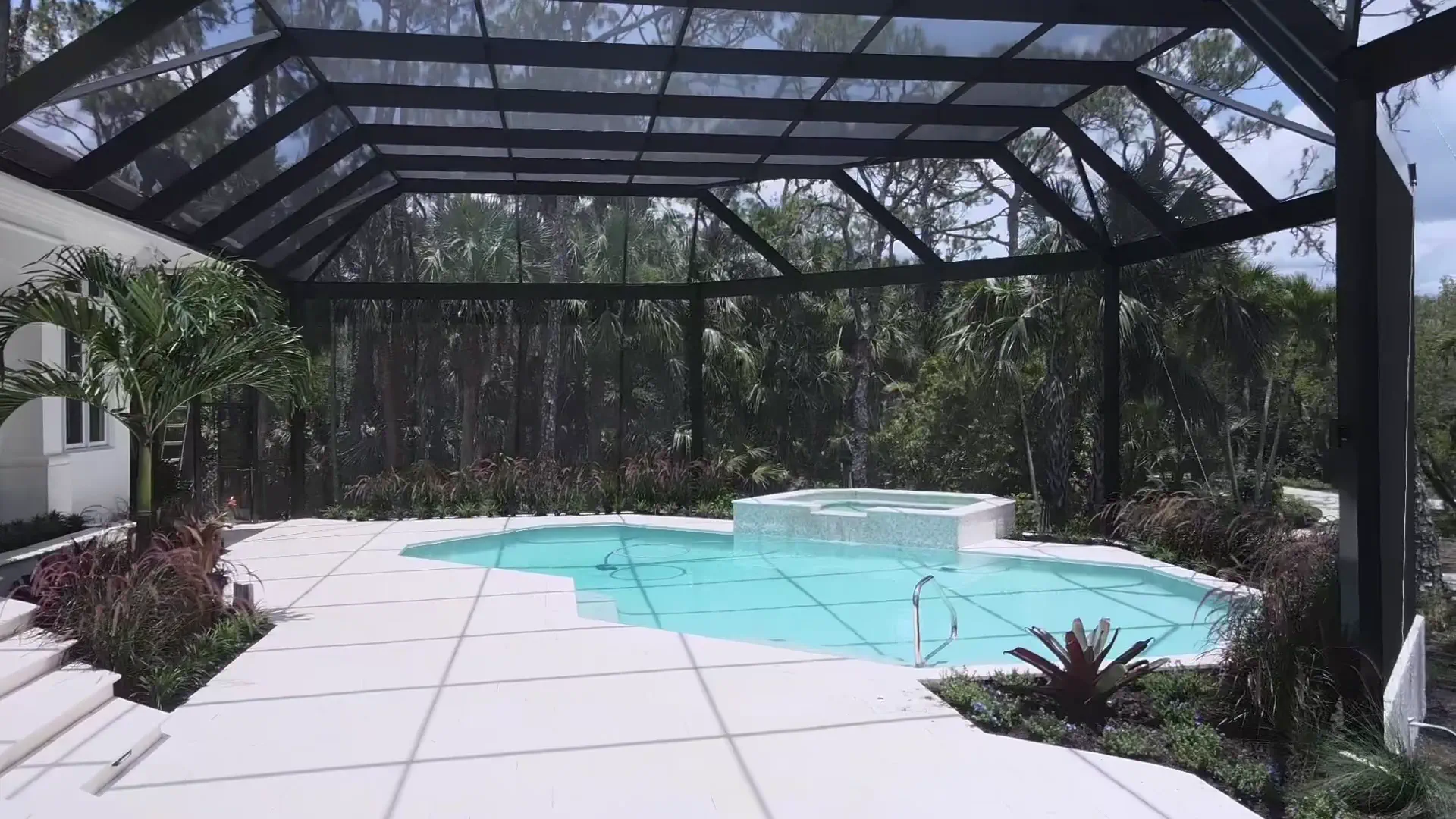 Interior of a clear-span screen enclosure over a pool and spa
