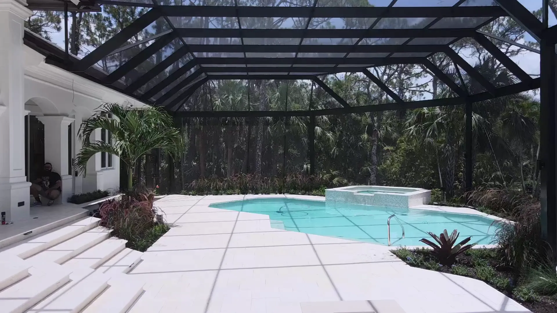 Interior of a clear-span screen enclosure over a pool and spa