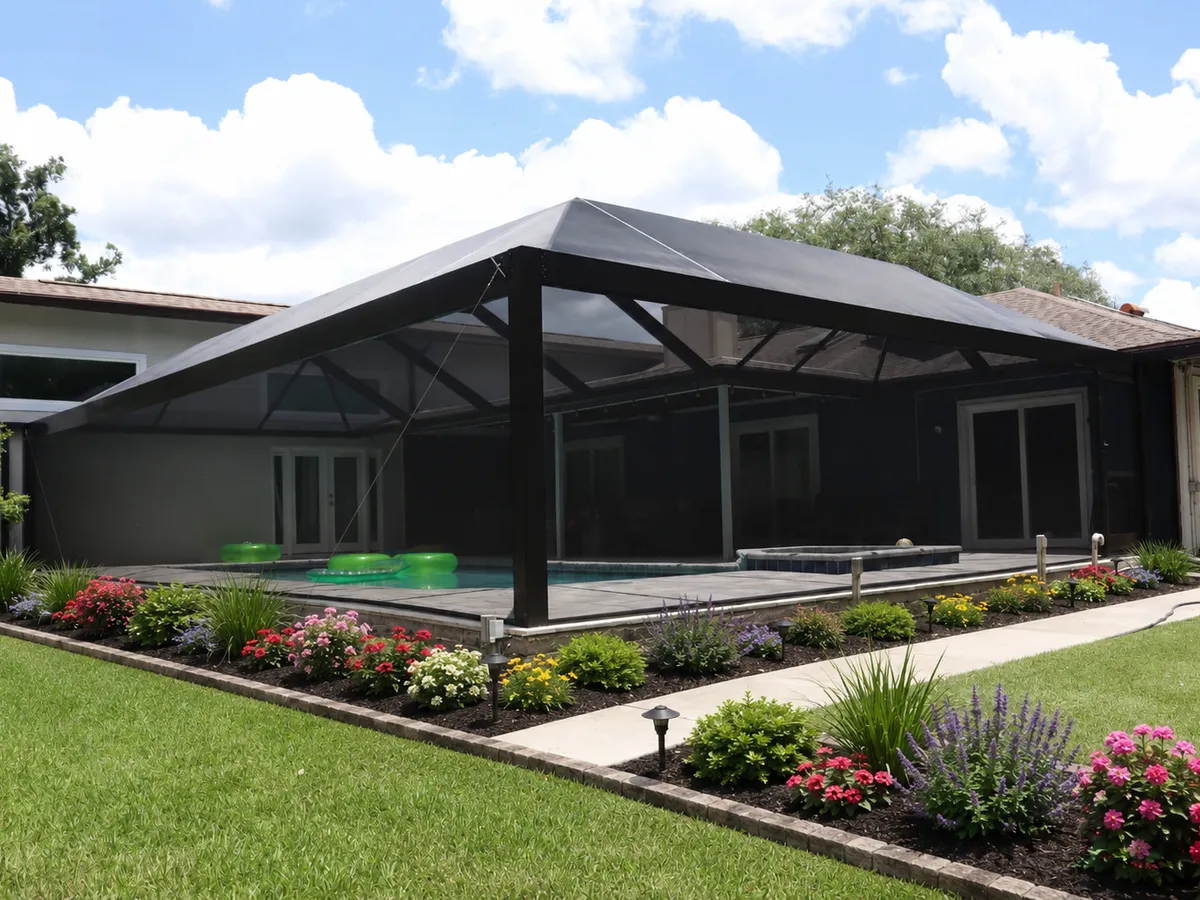 Screened pool cage spanning a pool deck, landscaped beds along the walk
