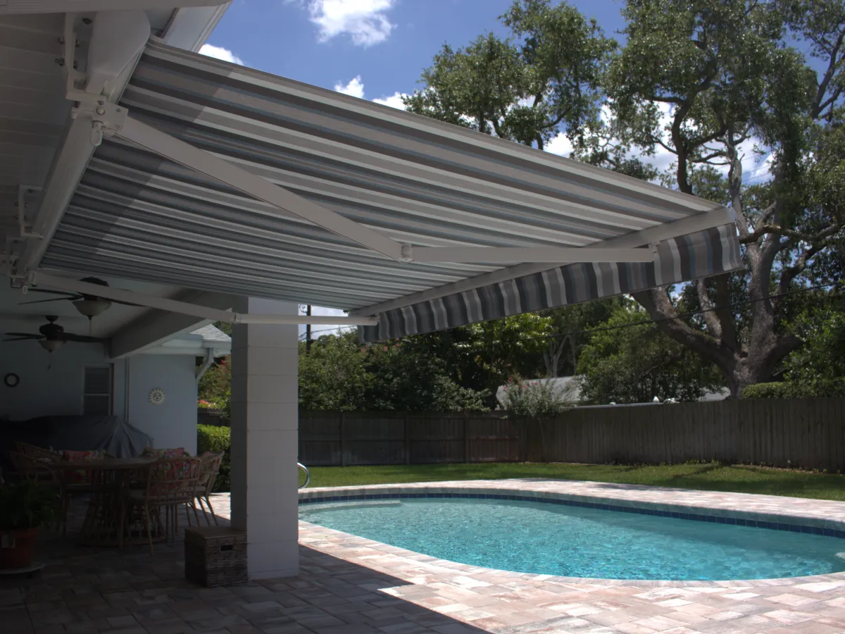 Striped awning extended over a poolside patio